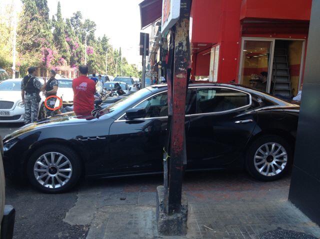 Police walk past illegally parked luxury car, despite ticket book in pants pocket.